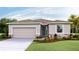 Charming single-story home featuring a two-car garage, lovely landscaping, and a welcoming front entrance at 10449 Gentle Rain Dr, Land O Lakes, FL 34638