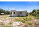View of the house's back exterior showing the backyard and light grey paint at 11009 Spivey Rd # 1, Gibsonton, FL 33534