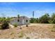 Charming single-story home with a spacious, undeveloped yard under a bright, sunny sky at 11009 Spivey Rd # 1, Gibsonton, FL 33534