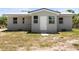 Street view of the front exterior featuring light grey paint and a newly installed metal roof at 11009 Spivey Rd # 1, Gibsonton, FL 33534