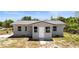 Charming single-story home with a new-looking metal roof and freshly painted light gray exterior at 11009 Spivey Rd # 1, Gibsonton, FL 33534