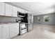 Bright kitchen with stainless steel appliances next to an open area with ample natural light at 11009 Spivey Rd # 1, Gibsonton, FL 33534