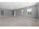 Open living room with modern light fixture, neutral paint, ceiling fan, and tile flooring at 11009 Spivey Rd # 1, Gibsonton, FL 33534