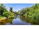 Scenic view of the tranquil canal waters surrounded by lush green vegetation and blue skies at 11009 Spivey Rd # 1, Gibsonton, FL 33534