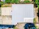 Overhead view of roof, driveway, back yard and a white privacy fence with mature trees providing shade at 1221 E Hamilton Ave, Tampa, FL 33604