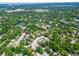 An aerial view showcases the home's location within a lush community of mature trees and landscaping at 1221 E Hamilton Ave, Tampa, FL 33604