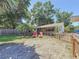 Spacious backyard featuring a screened patio, lush lawn, and mature trees at 1221 E Hamilton Ave, Tampa, FL 33604