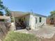 Rear view of the home showing the siding, concrete patio and some lawn equipment at 1221 E Hamilton Ave, Tampa, FL 33604