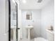 All-white bathroom with pedestal sink, subway tile, and modern fixtures, offering a clean and bright aesthetic at 1221 E Hamilton Ave, Tampa, FL 33604