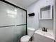 Updated bathroom featuring a sliding glass shower door, white vanity, and modern fixtures at 1221 E Hamilton Ave, Tampa, FL 33604