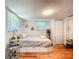 A cozy bedroom with hardwood floors, a large closet, and plenty of natural light at 1221 E Hamilton Ave, Tampa, FL 33604