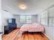 Cozy bedroom featuring wood floors, bright windows, and a modern dresser with a television at 1221 E Hamilton Ave, Tampa, FL 33604