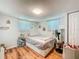 Cozy bedroom featuring hardwood floors, a simple bed frame, and bright windows with simple curtains at 1221 E Hamilton Ave, Tampa, FL 33604