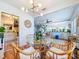 Open dining area with glass table, rattan chairs, modern lighting, and easy access to the kitchen and living room at 1221 E Hamilton Ave, Tampa, FL 33604