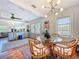 Cozy dining area with a glass table and wicker chairs features an open floor plan to the living room at 1221 E Hamilton Ave, Tampa, FL 33604