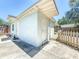 View of the exterior, showing a door to a basement, siding, and fenced yard at 1221 E Hamilton Ave, Tampa, FL 33604