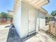 View of the exterior, showing a door to a basement, siding, and fenced yard at 1221 E Hamilton Ave, Tampa, FL 33604