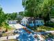 Charming exterior view of home featuring lush landscaping, a large driveway, and a detached garage at 1221 E Hamilton Ave, Tampa, FL 33604