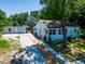 Charming single-story home with a long driveway and detached garage surrounded by mature trees at 1221 E Hamilton Ave, Tampa, FL 33604