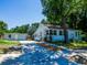 Charming exterior view of home featuring lush landscaping, a large driveway, and a detached garage at 1221 E Hamilton Ave, Tampa, FL 33604
