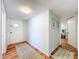Hallway with wood-look floors provides access to the front door and other rooms in the home at 1221 E Hamilton Ave, Tampa, FL 33604
