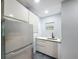 Updated kitchen with stainless steel refrigerator, white cabinets, and a sink with modern fixtures at 1221 E Hamilton Ave, Tampa, FL 33604