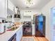 Compact kitchen features modern appliances, white cabinets, ample counter space, and views to the dinning room at 1221 E Hamilton Ave, Tampa, FL 33604
