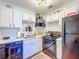 Functional kitchen with white cabinets, quartz counters, and black appliances at 1221 E Hamilton Ave, Tampa, FL 33604