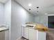 Modern kitchenette with white cabinets, wood countertop, and contemporary pendant lighting at 1221 E Hamilton Ave, Tampa, FL 33604