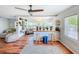 Open-concept living room featuring hardwood floors, a ceiling fan, breakfast bar and an abundance of natural light at 1221 E Hamilton Ave, Tampa, FL 33604