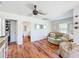 Bright living room features modern ceiling fan, hardwood floors, and comfortable seating with views into the bedroom at 1221 E Hamilton Ave, Tampa, FL 33604