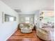 Comfortable living room featuring hardwood floors, neutral-toned furniture, and bright natural light at 1221 E Hamilton Ave, Tampa, FL 33604