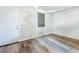 Bright living room with stylish wood flooring, a window with shade, and a white door at 1221 E Hamilton Ave, Tampa, FL 33604