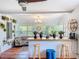 Open concept living room featuring a breakfast bar, pendant lighting, and large windows with a view of the lush yard at 1221 E Hamilton Ave, Tampa, FL 33604