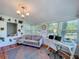 Cozy sunroom featuring a comfortable couch, large windows, a desk area, and bright natural light at 1221 E Hamilton Ave, Tampa, FL 33604