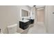 Modern bathroom featuring a double vanity with a unique, curved design and a large, illuminated mirror at 1304 N Ferrell St, Plant City, FL 33563