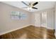 This bedroom features hardwood flooring, a ceiling fan, and a door to a connecting bathroom at 1304 N Ferrell St, Plant City, FL 33563