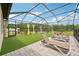 Spacious screened-in backyard with lounge chairs, artificial turf, and a playground at 13098 Wellspring Dr, Lithia, FL 33547