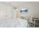 Bright bedroom with a floral quilt bed, desk and chair, and white walls at 13098 Wellspring Dr, Lithia, FL 33547