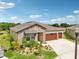Beautiful single-story home with stone details, lush landscaping, and a wide driveway leading to a two-car garage at 13098 Wellspring Dr, Lithia, FL 33547