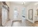 Welcoming foyer with wood flooring, storage bench and views into the main bedroom at 13098 Wellspring Dr, Lithia, FL 33547