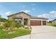 Charming single-story home showcases a stone facade, manicured landscaping, and a three-car garage for convenience and curb appeal at 13098 Wellspring Dr, Lithia, FL 33547