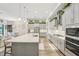Modern kitchen featuring gray cabinets, a large center island, stainless steel appliances, and stylish pendant lighting at 13098 Wellspring Dr, Lithia, FL 33547