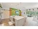 Open kitchen and living area with a large island, stainless steel appliances, and custom barn door at 13098 Wellspring Dr, Lithia, FL 33547