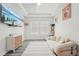 Well-lit living room with a white couch, modern TV, geometric ceiling, and two windows at 13098 Wellspring Dr, Lithia, FL 33547