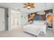The bright and airy primary suite features a decorative ceiling fan, accent wall, and lots of natural light at 13098 Wellspring Dr, Lithia, FL 33547