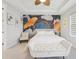 This main bedroom features a leaf accent wall, a ceiling fan, and a plush white bench at 13098 Wellspring Dr, Lithia, FL 33547