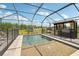 Screened-in pool area with outdoor kitchen, offering a luxurious and private outdoor retreat in a backyard setting at 13098 Wellspring Dr, Lithia, FL 33547