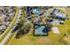 Aerial view of community pool, tennis court, and parking lot bordered by trees and foliage adjacent to neighborhood road at 13201 Wellington Hills Dr, Riverview, FL 33579