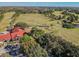 An aerial image of a golf course with a clubhouse featuring a red roof with multiple surrounding trees at 13201 Wellington Hills Dr, Riverview, FL 33579